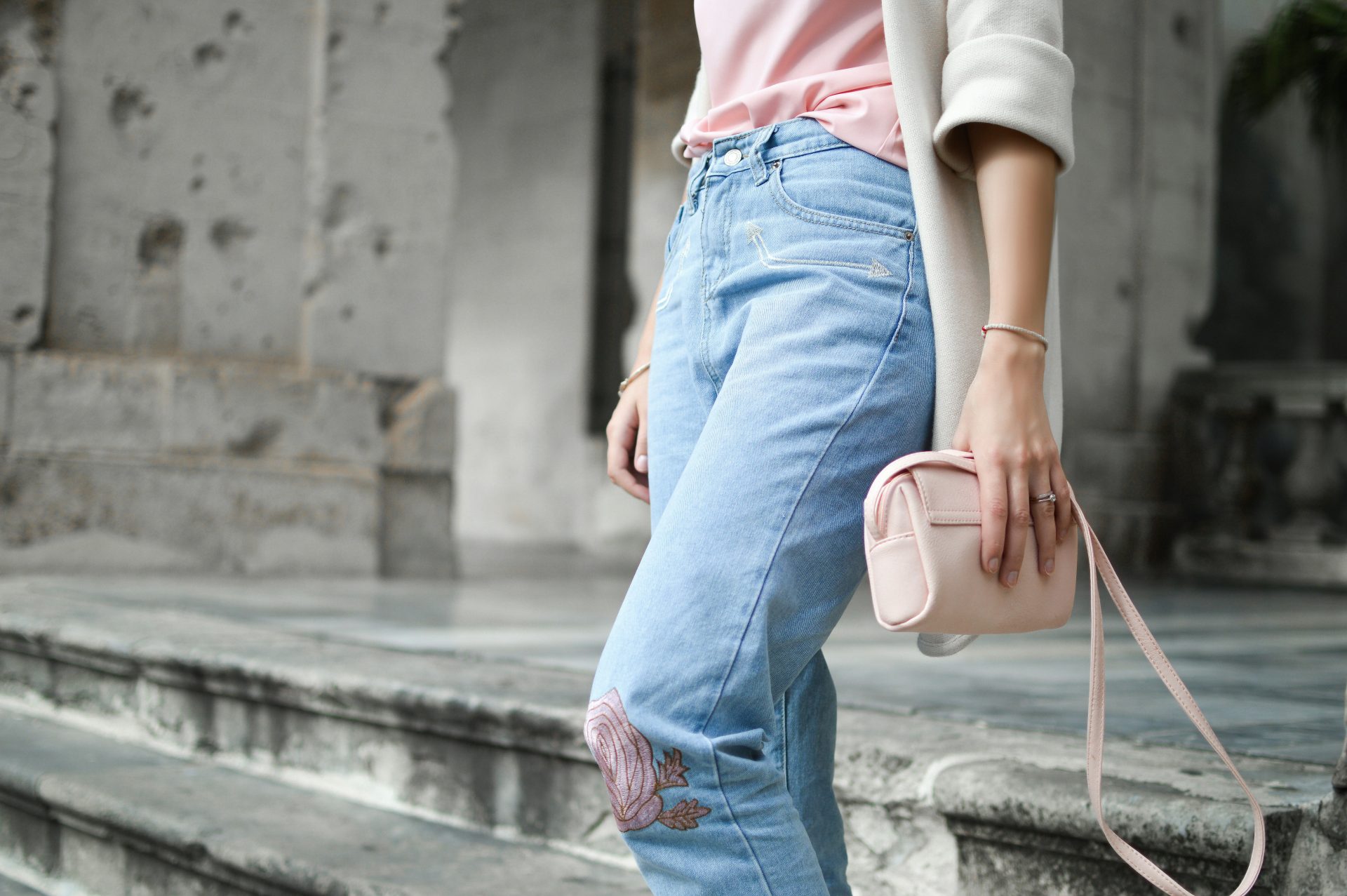 We're loving this chic sustainable look! Light wash jeans with floral embroidery, paired with a blush top and cream cardigan. Our favourite way to style eco-friendly denim? Add a pastel crossbody for a pop of colour. Discover more sustainable styling tricks on the blog!