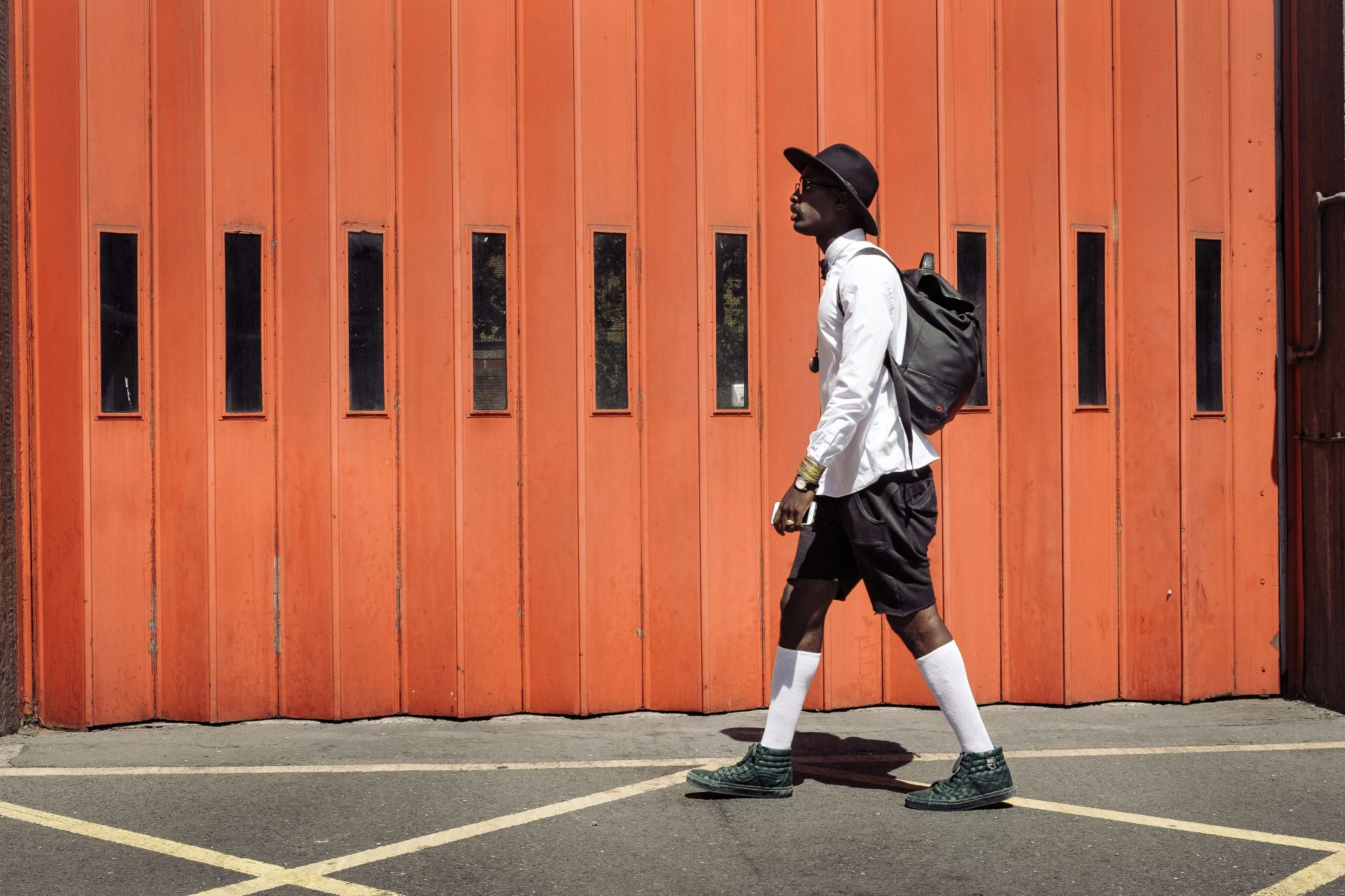 We're loving this dapper London look! Crisp white shirt, black shorts, and knee-high socks create a brilliant contrast. The fedora and backpack add urban flair, while green boots make a bold statement. Discover our top styling tricks for nailing this look and more London fashion secrets on the blog! #Londons #Secrets #Urban #London #Look #How #Streets #Became #PinterestInspiration