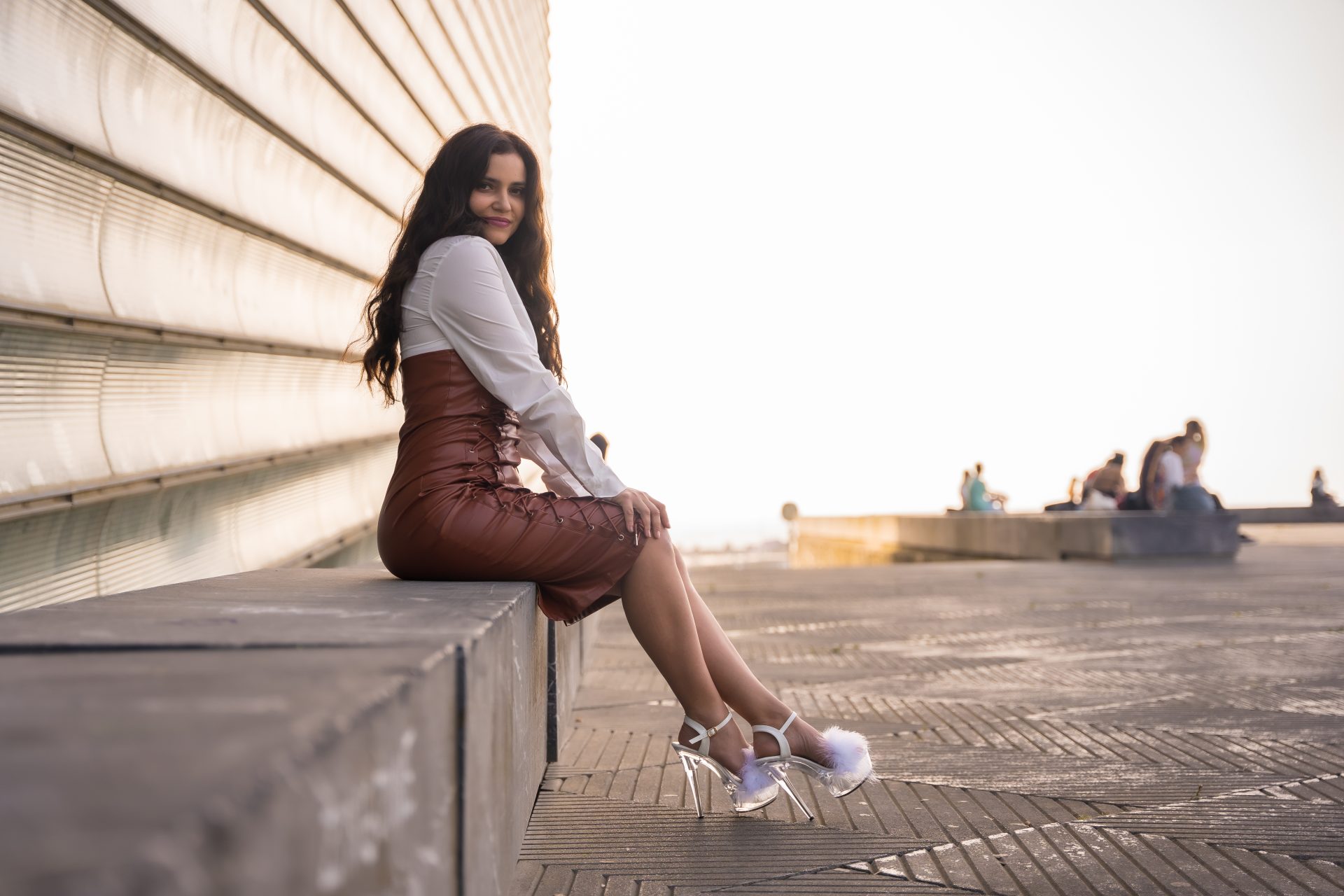 We're loving this quayside couture look! A crisp white blouse paired with a striking brown leather skirt and fluffy platform heels creates the perfect blend of vintage and modern. But there's a clever styling trick that pulls it all together. Curious? Pop over to the blog for our complete guide on mastering this head-turning ensemble. Don't miss out on our expert tips!
