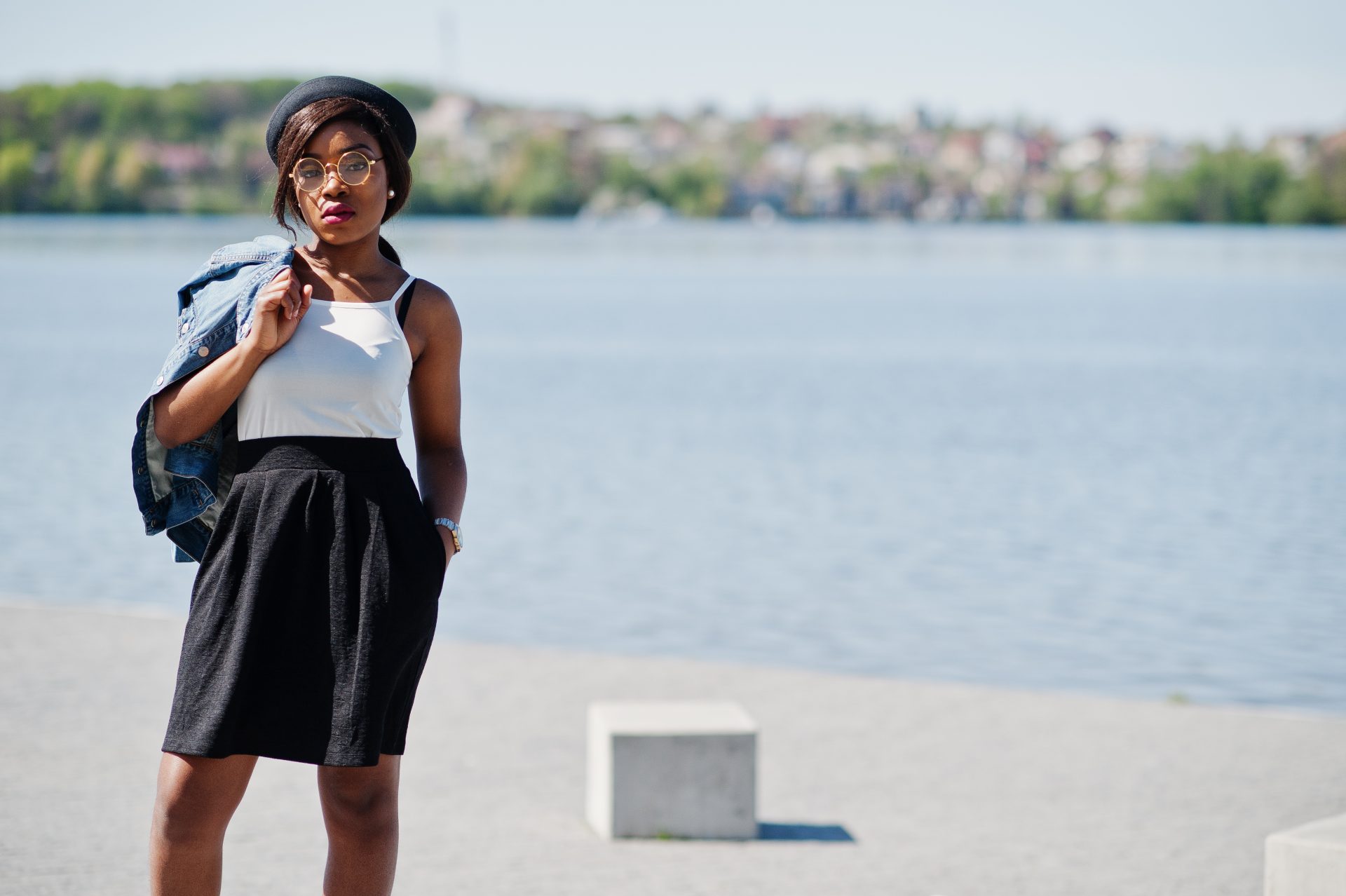 We're loving this quayside look! A classic white cami and black skirt get a modern twist with a denim jacket, beret, and round glasses. Our favourite way to style? Drape that jacket for effortless cool. Discover our complete guide to nailing riverside fashion on the blog!