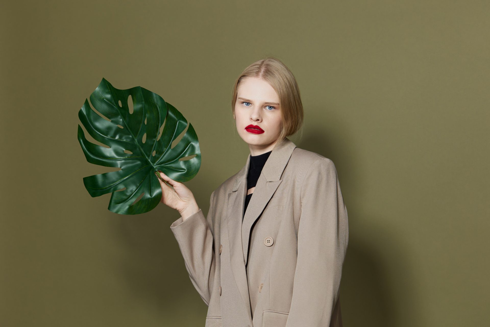 We're loving this chic, eco-conscious look! A neutral oversized blazer paired with a black top creates a timeless base. The bold red lip adds a pop of colour, while the tropical leaf hints at nature-inspired style. Discover our top sustainable fashion tips and transform your wardrobe. Click for the full guide!