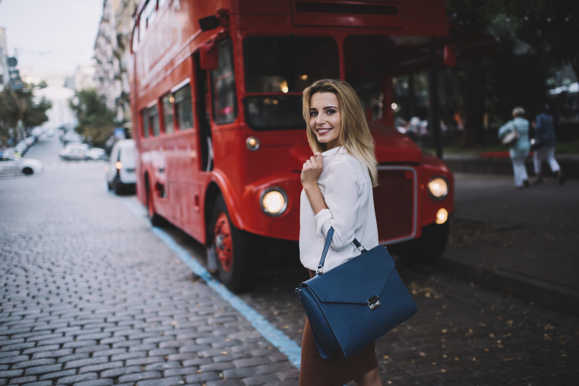 We're loving this effortlessly chic London look! A crisp white blouse paired with a navy structured bag creates the perfect city ensemble. Our favourite way to style? Add a pop of red like the iconic double-decker bus. Discover more insider tips for mastering urban fashion on our blog! #Style #Urban #Street #London #Mastering #Chic #City #Our