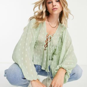 ASOS DESIGN dobby long sleeve blouse with lace up front & peplum hem in sage-Green